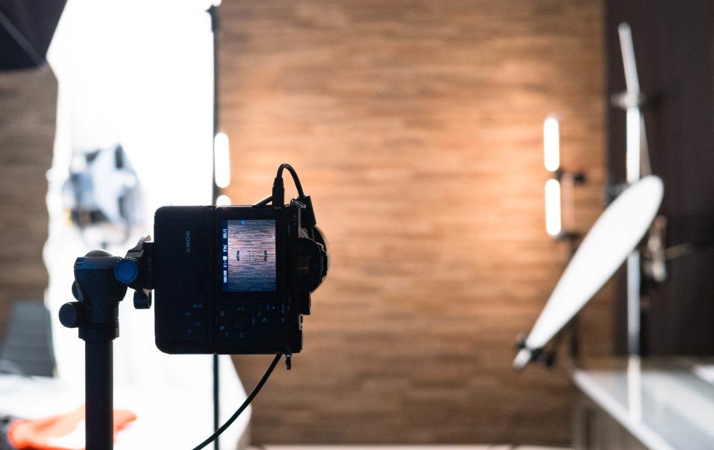 A camera is set up with various lighting to capture headshots. 