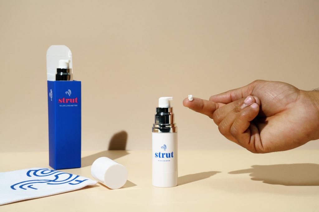 A hand with Strut topical medication on one finger before application. 